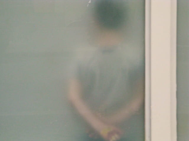 Enfant dans une école derrière vitre opaque